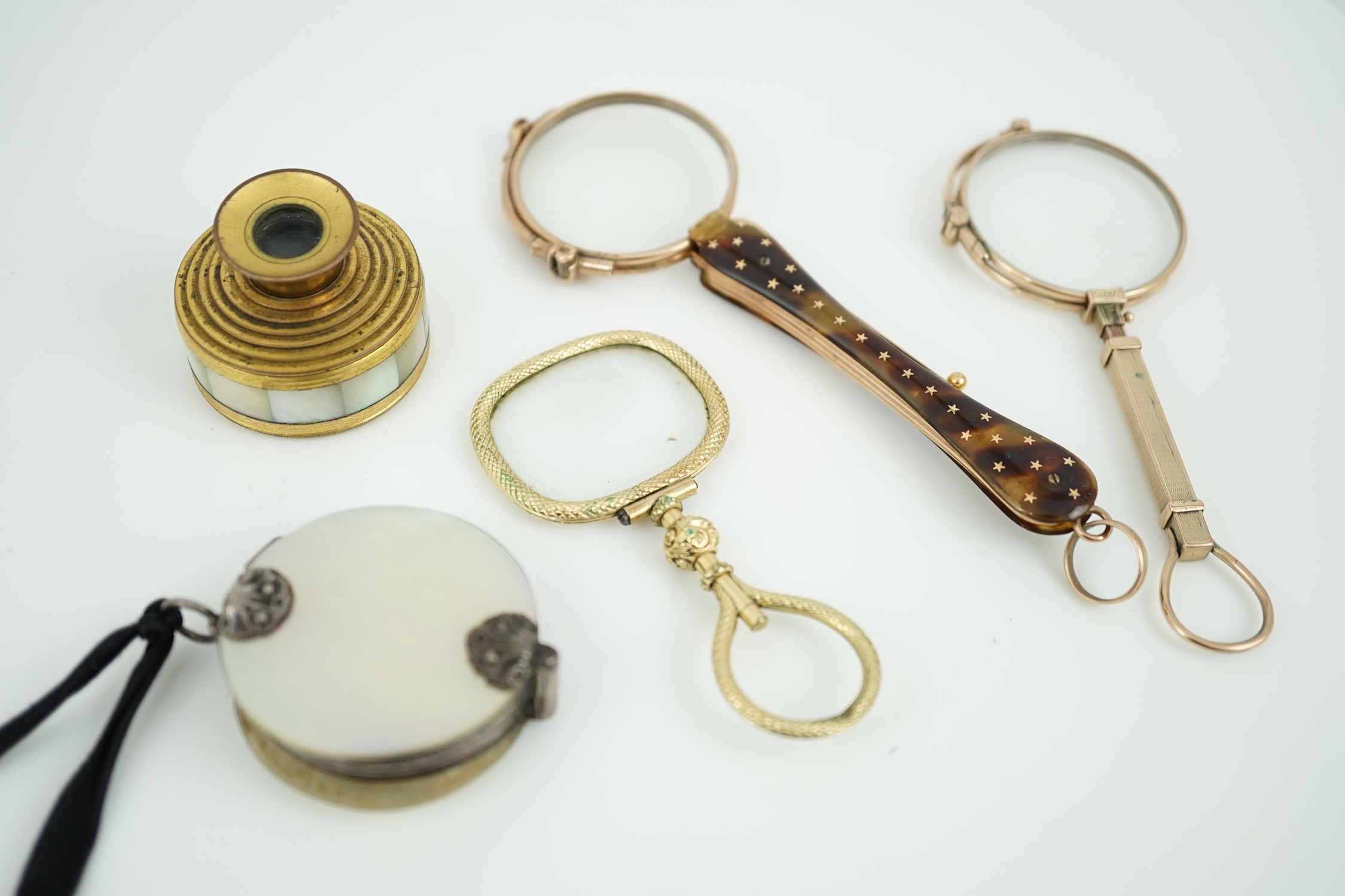 A 19th century mother of pearl and white metal mounted folding double magnifying glass, 40mm, two yellow metal mounted lorgnettes including Hamblin, London, a spy glass and a mother of pearl mounted gilt metal monocular.